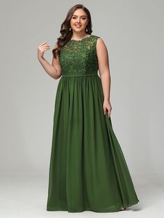 a woman in a long green dress with lace detailing on the top and bottom, posing for