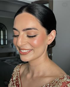 a woman in a red dress smiling and looking at the camera with her eyes closed