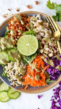 a bowl filled with rice, carrots, cucumber and guacamole