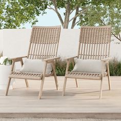 two chairs sitting next to each other on top of a wooden floor in front of a tree