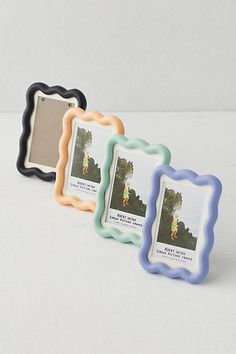 three different colored frames sitting next to each other on a white surface with an image in the middle