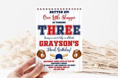 a person holding up a baseball themed birthday party card with the words three graveson's on it