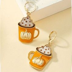 a pair of pumpkin themed coffee mug earrings