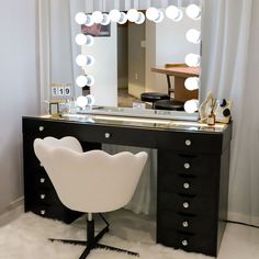 a desk with a chair, mirror and lights on it