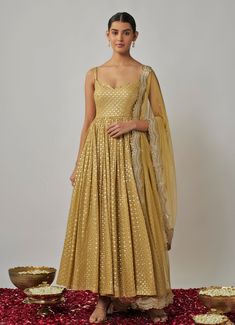 This stunning Champagne Gold Sequin Embroidered Anarkali Set embodies elegance and timeless sophistication. Crafted from lightweight georgette, this champagne anarkali is beautifully adorned with intricate sequin and gold threadwork, offering a hint of glamour and shine. The fitted bodice with a wide neckline and delicate noodle straps creates a flattering, modern silhouette, while the flowing pleated skirt adds grace. Paired with a matching lycra churidar, this set is completed with a gold soft net dupatta, featuring an exquisite scalloped sequin border and scattered butti embroidery. Perfect Anarkali for Sangeet, weddings, or festive celebrations. Composition : Anarkali - Viscose Georgette, Dupatta - Soft Net and Churidar - Lycra Care: Dry Clean Only and Vacuum Storage This product can b Butti Embroidery, Noodle Strap, Embroidered Anarkali, Georgette Dupatta, Vacuum Storage, Indian Wedding Wear, Net Dupatta, Gold Sequin, Churidar