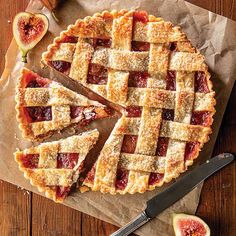 a pie with slices cut out on top of it and some fruit next to it