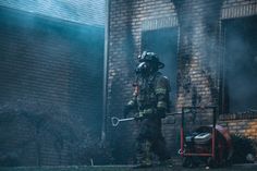 a firefighter is using a hose to extinguish the flames from his house