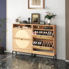 a wooden cabinet with many pairs of shoes on it and a potted plant in the corner