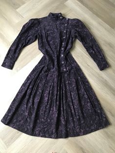 "So good! Rare gem of a vintage 1980s Laura Ashley dress made in Great Britain. Rich purple floral patterned soft pinwale corduroy. Asymmetrical side button front with puffed long sleeve and high neck; dropped waist with box pleats; princess seams at back for nice fit; two-button sleeve cuffs. Simply an extraordinary dress in excellent condition. Photographed on a size 8 form US size 10 / UK size 12 Measures  Bust: 36\" Torso/ Waist: 34\" Hips/ Drop Waist : 40\"" Long Sleeve Vintage Dress With Buttons For Fall, Long Sleeve Vintage Dress For Formal Fall Events, Formal Vintage Long Sleeve Dress For Fall, Fall Vintage Long Sleeve Dress With Buttons, Formal Long Sleeve Vintage Dress For Fall, Retro Vintage Long Sleeve Dress With Buttons, Retro Long Sleeve Vintage Dress With Buttons, Fitted Vintage Dress With Buttons For Fall, Formal Vintage Dress With Buttons For Fall