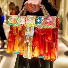 a woman holding a multicolored handbag in her hands