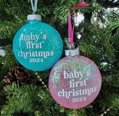 two baby's first christmas ornaments hanging from a tree