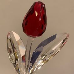 a glass sculpture with a red flower on it