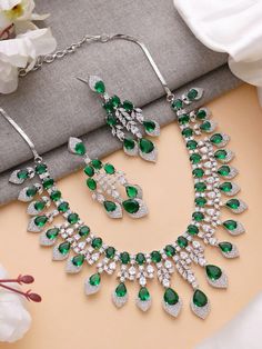 Add a touch of glamour and sophistication with this high quality necklace set in beautiful emerald green stones. The stones in this set bling and look close to the real thing. This set is sure to make heads turn! 
It features an adjustable necklace and a pair of earrings. It can be paired perfectly with both ethnic and western outfits. 
In case of any queries, please feel free to reach out. Happy shopping! Green Jeweled Necklace For Anniversary, Green Jeweled Necklaces For Anniversary, Dazzling Green Emerald Necklace, Dazzling Green Emerald Necklace For Anniversary, Dazzling Green Emerald Necklace For Formal Occasions, Green Sparkling Stones Jewelry Sets For Party, Fine Jewelry Emerald Bridal Necklace For Anniversary, Green Jewels Jewelry For Formal Occasions, Formal Green Jewelry With Jewels