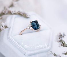 an engagement ring with a blue stone surrounded by flowers