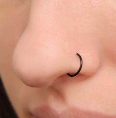 a woman with a nose ring that has a crescent design on it's nose