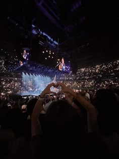 people taking pictures with their cell phones in front of an audience at a music concert