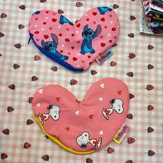 two heart shaped bibs sitting on top of a table