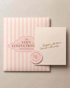 two pink and white striped envelopes with gold foil lettering on the front, one has a label that says cozy confection