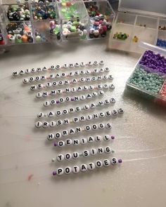 many beads are arranged in rows on a table with plastic containers full of small beads