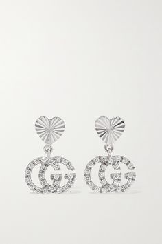 Gucci's earrings have been made in Italy from 18-karat white gold - the archival 'GG' moniker honors label founder Guccio Gucci. Dangling from heart-shaped posts with an etched sunburst, they're dusted with glinting diamonds. The petite drops move prettily as you do. Luxury Platinum Diamond Earrings Hallmarked, Gucci Round Earrings For Formal Events, Gucci Round Earrings For Formal Occasions, White Platinum Hallmarked Earrings, Luxury Round Gucci Earrings, Classic Gucci Earrings For Anniversary, Gucci Luxury Round Earrings, Luxury Gucci Earrings, Designer White Gold Diamond Earrings For Formal Events