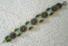 "This beautiful bracelet has seed beads, green Czech glass beads, antique gold accent beads and antique gold filigree settings accented with rhinestones. 7\" long. Toggle clasp." Elegant Brass Bracelets For Jewelry Making, Elegant Antique Gold Bracelet Jewelry, Victorian Brass Bracelet Jewelry, Victorian Adjustable Brass Bracelets, Victorian Style Brass Bracelets, Victorian Brass Bracelet, Handmade Antique Gold Jewelry For Formal Occasions, Victorian Brass Bracelets In Antique Gold, Antique Gold Beaded Jewelry With Round Beads