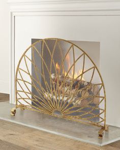 a fireplace with a fire in the middle and a metal screen on it's side