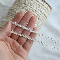 a person is holding three different types of chains in their hand, one being white and the other silver