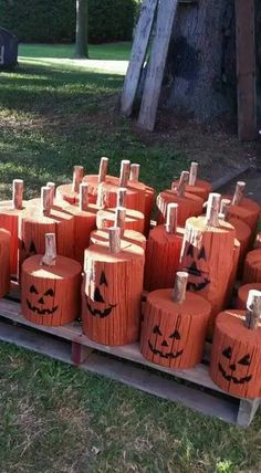 pumpkins painted with faces on them are sitting on a pallet in the grass