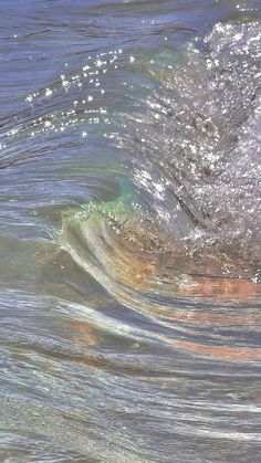 a person riding a surfboard on top of a wave in the ocean with bubbles