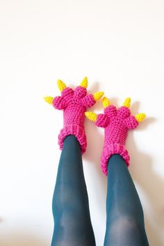 two crocheted giraffes sitting on top of each other's legs