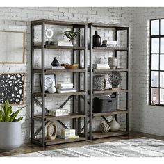 an open bookcase with many books on it in front of a white brick wall