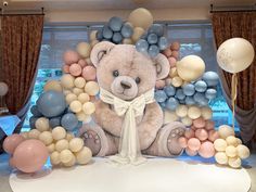 a large teddy bear surrounded by balloons