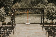 an outdoor wedding setup with chairs and a cross