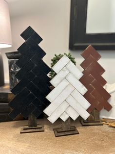 three wooden trees sitting on top of a table next to a lamp and mirror in a room