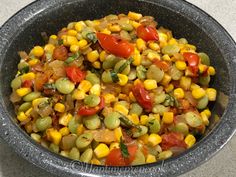 a bowl filled with corn and vegetables on top of a table