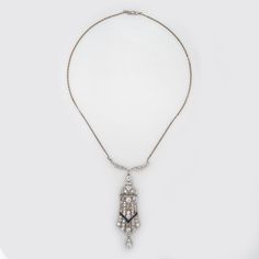 Finely detailed vintage Art Deco era diamond necklace (circa 1920s to 1930s), crafted in 14 karat white gold (chain) and platinum.    Old European cut diamonds total an estimated 4 carats. Small French cut sapphires (lab) accent the mount. The diamonds are estimated at I-J color and VS2-I2 clarity.    Bold and distinct in design, the necklace makes a great statement! Diamonds shimmer in the large drop that measures 2 1/2 inches in length, a testament to the beauty of everything you love about Art Deco era jewelry. The necklace is great worn as a statement piece or layered with your fine jewelry from any era.    The necklace is in very good original condition and was lightly cleaned and polished.    Particulars:    Weight: 14.6 grams    Stones: Old European cut diamonds total an estimated 4 Evening Fine Jewelry Platinum Necklaces, Fine Jewelry Platinum Necklaces For Evening, Evening Platinum Fine Jewelry Necklaces, Evening Platinum Diamond Cut Necklace, Evening Platinum Necklace With Diamond Cut, Platinum Diamond Cut Necklace For Evening, Formal Platinum Necklace With Rose Cut Diamonds, Antique White Gold Necklace With Diamond Accents, Vintage Pendant Necklace With Brilliant Cut