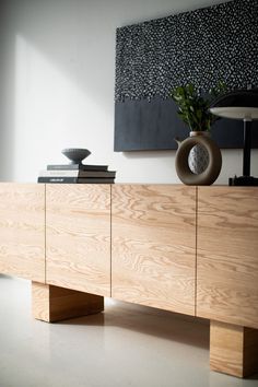 a wooden sideboard with two vases on top