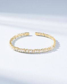 Experience the timeless elegance of our original 'Classic Diamond Fireworks' bangle, designed by Suzanne 10 years ago. The bangle features 1.20 carats of baguette white diamonds, set in Suzanne's signature fireworks design, creating a mesmerizing sparkle that catches the eye from every direction. This bangle is easy to stack with other pieces, making it a versatile addition to your jewelry collection. Handcrafted with an 18K spring gold wire, it's also flexible and easy to slip on and off, ensuring maximum comfort and ease of wear. Whether dressed up or dressed down, this classic bangle is the perfect accessory for any occasion, adding sophistication and glamour to your outfit. Details 18k yellow gold, rose gold, or white gold 1.20 carats of baguette white diamonds Ref: AKB117 Party Bracelets With Baguette Diamonds And Cubic Zirconia, White Gold Bangle With Baguette Diamonds, White Diamond Bracelet With Baguette Diamonds For Gift, White Bracelets With Baguette Diamonds As Gift, White Bracelets With Baguette Diamonds For Gift, Diamond White Bangle Bracelets With Baguette Diamonds, Anniversary Cubic Zirconia Bangle With Baguette Diamonds, Wedding Bangle With Baguette Diamonds, Baguette Diamond Bangle Bracelet For Weddings