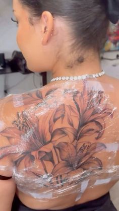 a woman with tattoos on her back covered in plastic