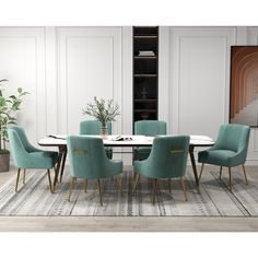 a dining room table with blue chairs and a rug on the floor in front of it