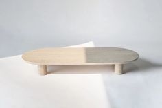 a wooden skateboard sitting on top of a white surface