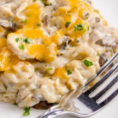 a white plate topped with macaroni and cheese covered in melted cheese, parsley