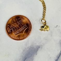 "A beautiful 14K solid yellow gold tiny etched lucky elephant pendant charm. It has a soldered ring to attach to a bracelet or a necklace. The very delicate pendant measures 6.1mm tall with bail and without the soldered ring and 6.9mm wide. It can be used as a necklace pendant or a bracelet charm and would make a perfect gift. The pendant can be paired with a shiny 14K Yellow Gold 1.2mm cable link chain in either 16\" or 18\" length or with a 16\" 14K gold-plated cable link chain. All items come Dainty Tiny Recycled Gold Jewelry, Dainty 14k Gold Hypoallergenic Charm Necklaces, Gold Charm Necklaces With Round Pendant, Gold Charm Necklace With Round Pendant, Dainty Yellow Gold Brass Charm Necklace, Dainty Yellow Gold Dangle Charms, Dainty Charms Suitable For Gifts, Dainty Yellow Gold Charm Necklace For Good Luck, Dainty Small Charms Jewelry