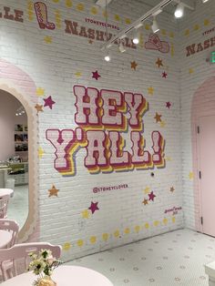 there is a wall with the words hey y'all painted on it in pink and yellow