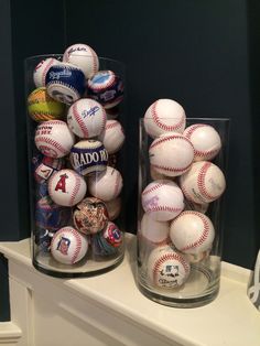 two vases filled with baseballs sitting on top of a white mantle next to each other