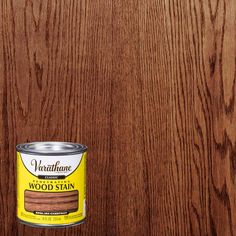 a can of wood stain sitting on top of a wooden floor