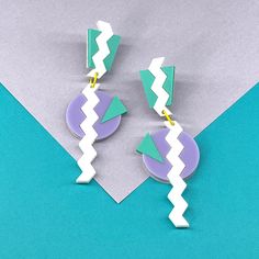 Enjoy the bold and vibrant energy of 80's Memphis with these fun statement earrings. Created with lavender, aqua, and white, these earrings will every outfit a work of art. These stunning earrings are 3 7/8 inches long and have stainless steel earposts. Made to order, please allow 1-2 weeks to ship. Retro White Dangle Earrings, Retro White Drop Earrings, Retro White Earrings For Gift, Retro White Dangle Jewelry, Bold White Jewelry For Gifts, Bold White Jewelry For Gift, Modern White Geometric Earrings, Funky White Jewelry As A Gift, Funky White Jewelry For Gifts