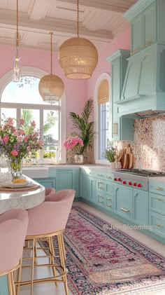 a pink and blue kitchen with lots of counter space in the center, along with an area rug on the floor