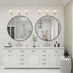 two round mirrors are above the double sinks in this white bathroom with black and white accessories