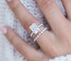 a close up of a person's hand with a ring on their finger and an engagement band